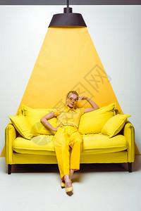 坐在沙发上看着白色和黄色相机的漂亮金图片