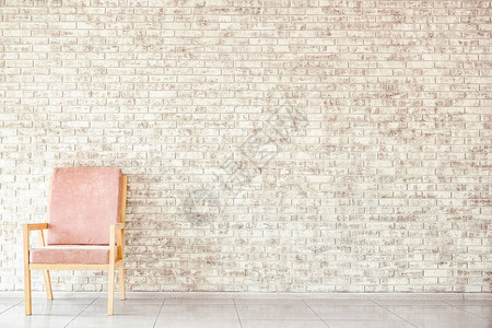 砖墙附近的现代扶手椅图片