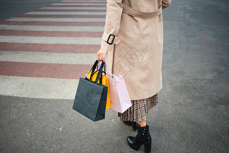 女人拿着购物袋走行人横道特写图片