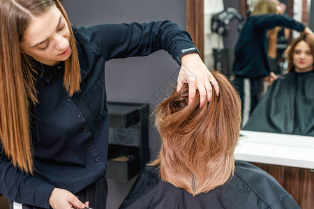 专业女理发师在美容院把女人的发图片