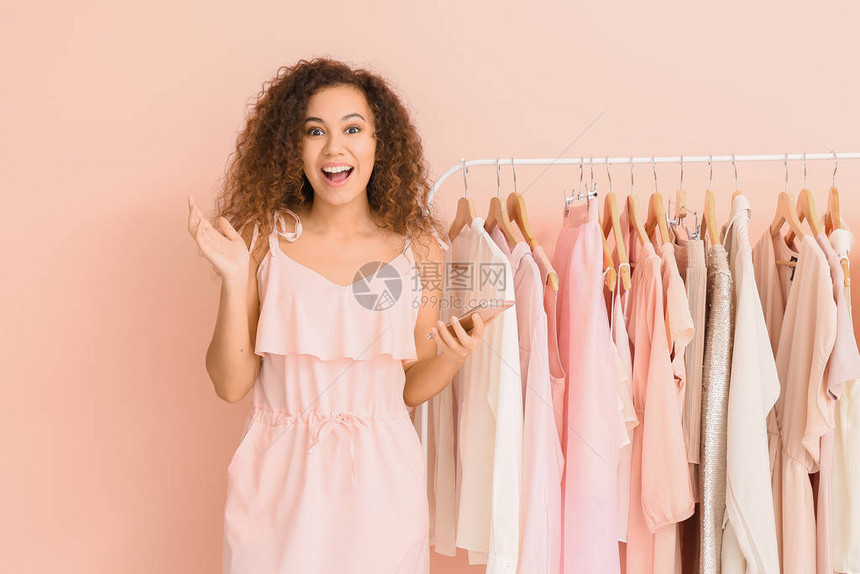 女孩站在粉色衣服旁打招呼图片