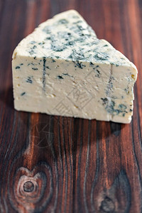 深色木质背景上的大块蓝纹奶酪背景图片