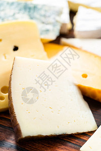 深色木制背景上的各种大美食奶酪楔子背景图片