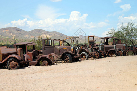 沙漠中废弃的旧汽车和锈迹斑的汽车图片