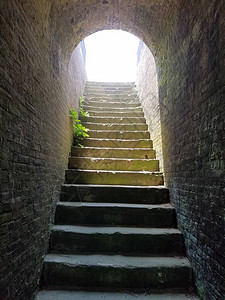 非常古老的楼梯和楼梯尽头的明亮灯光图片