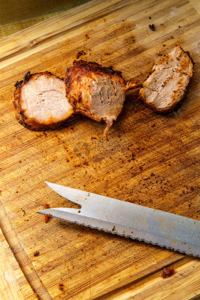 在木切板上切片的烤猪里脊肉图片