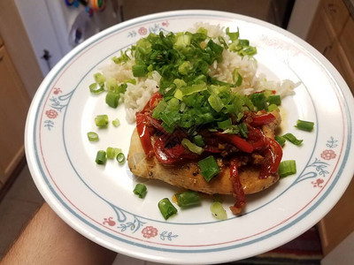 厨房里有鸡肉红辣椒和米饭的手拿着盘子图片