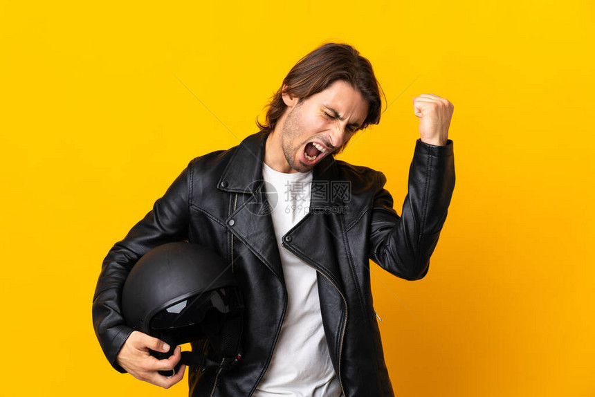 骑着摩托车头盔的男子在黄色背景下被孤图片