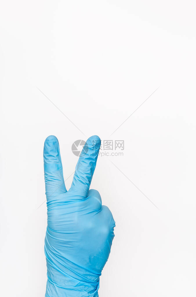 医疗手套在白色背景上显示胜利标志胜利的手势图片