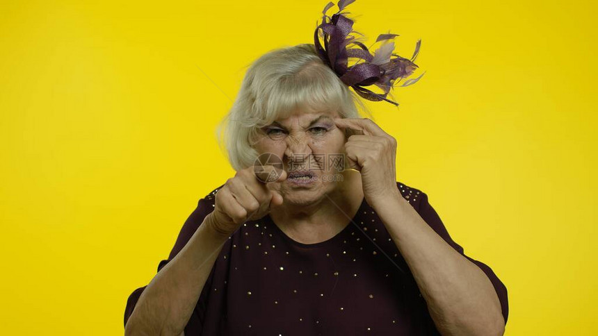 生气的老妇人表现出愚蠢的姿态图片