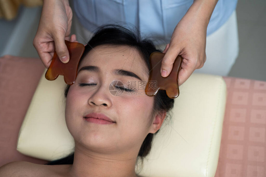 亚洲年轻女在亚洲美女接受面部刮痧治疗图片