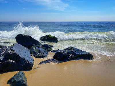 沿着泽西海岸的长树枝上的岩石上拍打着海浪图片