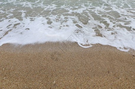 海滩上有许多鹅卵石的海水图片