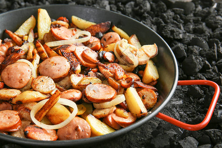 煎锅配美味的土豆和炭火香肠图片