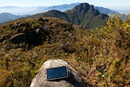山景中岩石上的电子平板电脑图片