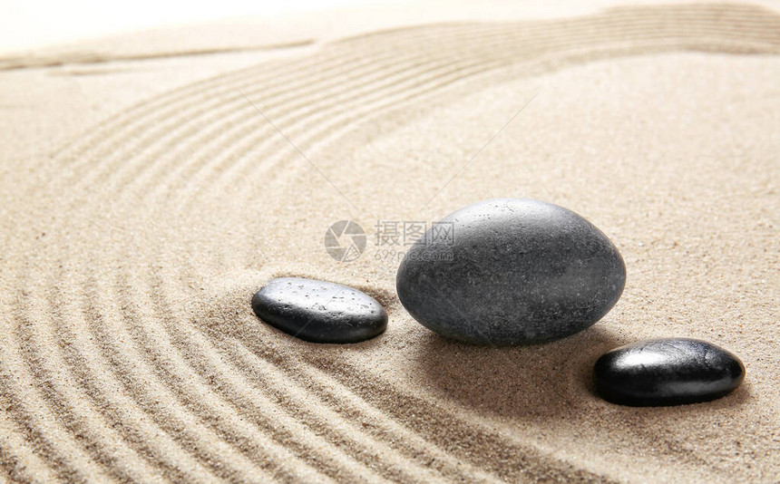 带线条的沙子上的石头禅宗概念图片