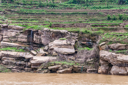 长江水从海岸线上的棕灰色岩石上流过背景图片