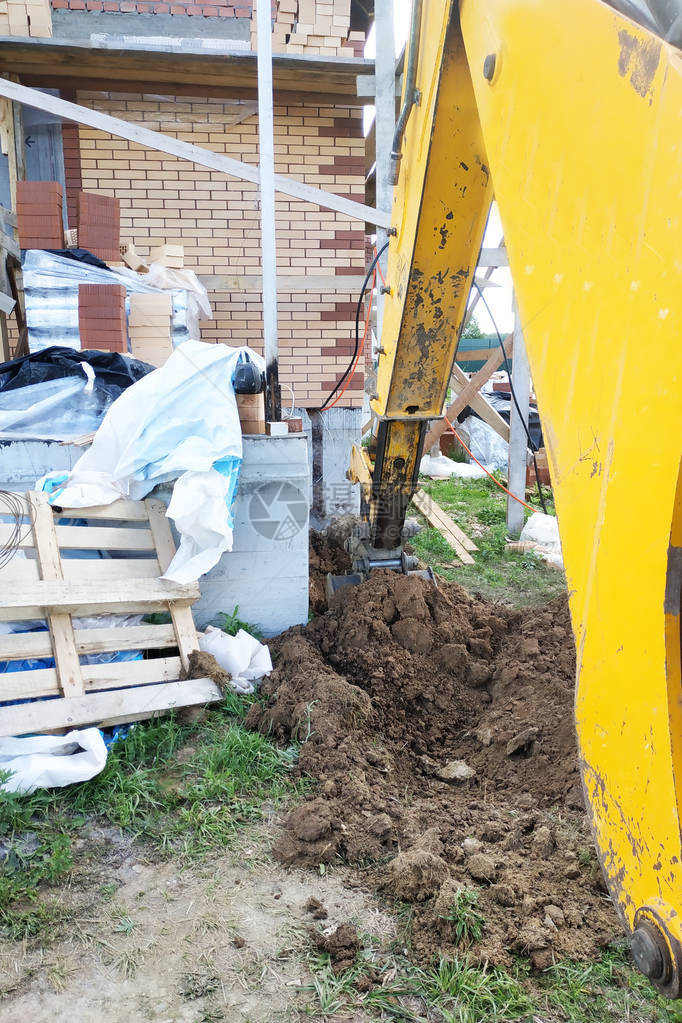 挖土机在有线房屋附近挖壕沟图片