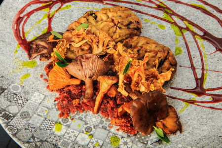 用蘑菇和肉类配上原餐厅盘子上的草药和酱汁提图片