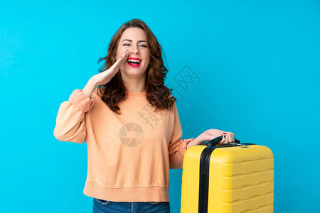 旅行妇女带着手提箱在孤立的蓝底色背景上大喊叫图片