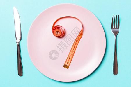 叉子和盘子上面有彩色背景的胶图片
