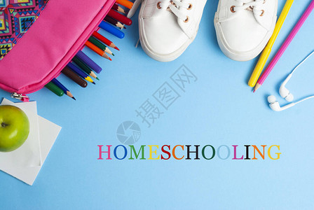 以蓝背景和彩色铅笔及运动鞋进行家庭课本教学图片