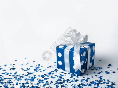 蓝色礼品盒与白色背景上的蝴蝶结与五彩纸屑2020年的颜色是经典的蓝图片