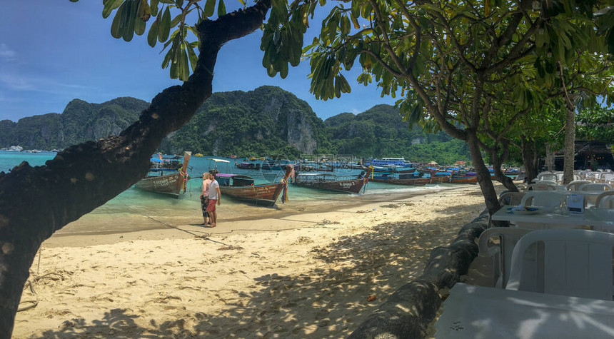 俯瞰皮岛的海滩有一条树线在黄沙上造成阴影小船停靠在海岸线上图片