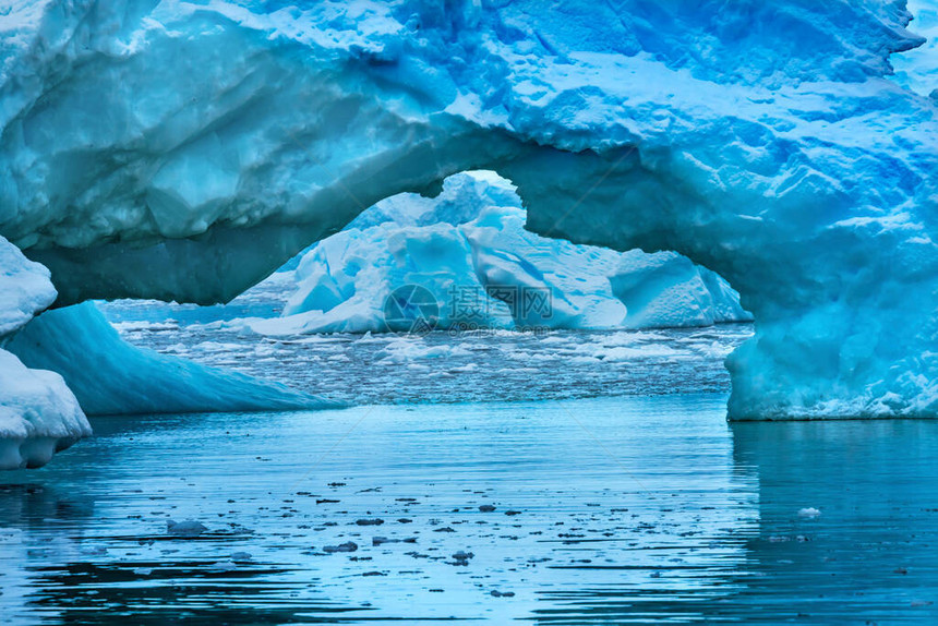 冰雪漂浮的蓝色冰山拱门反射天堂湾平原峡谷南极洲图片
