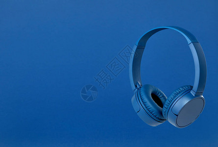 蓝色背景上的蓝色无线耳机图片