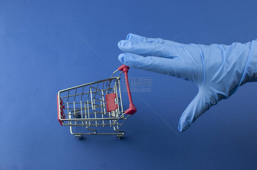 空超市的电车和女人用蓝色的医学手套图片