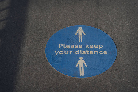 请在英国伦敦人行道上保持距离的社交失常标志因为科罗图片