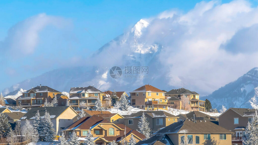 以华沙奇山顶峰的美景环绕着云蓝天空的全景房屋住宅和自然景观在冬季充斥着雪图片