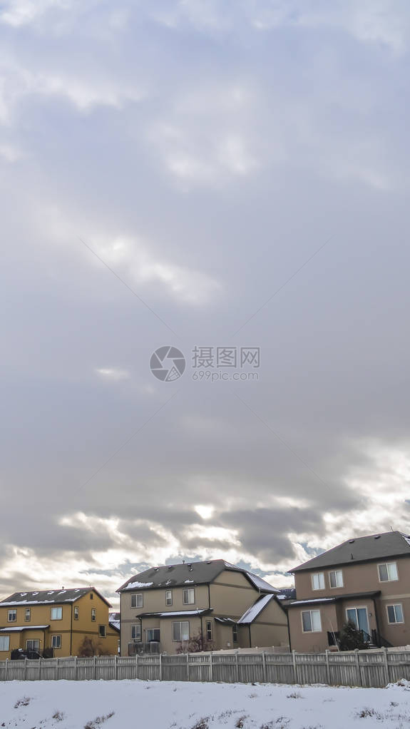 蓝色天空下布满白木栅栏厚云的房屋场面图片