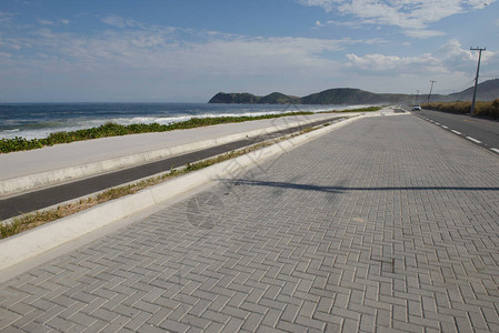 夏日荒凉海滩上的沥青自行车道图片