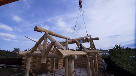 工人在用起重机建造小屋夹子建造乡村木屋木材设计的建造者在蓝天背景下将起背景图片