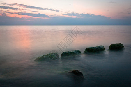日落时有石头的海岸图片