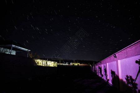 夜间乡村景观星迹效应在山上和夜空中的树木上产生图片