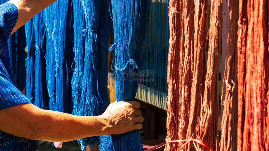 工艺和工艺传统的伊桑泰国棉靛蓝编织手拿着靛蓝染色布和天然染料或树皮泰国图片
