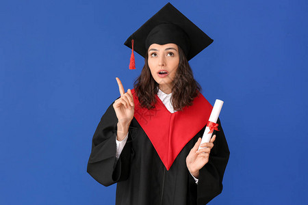 有文凭的女毕业生在彩色背景上举起食指图片