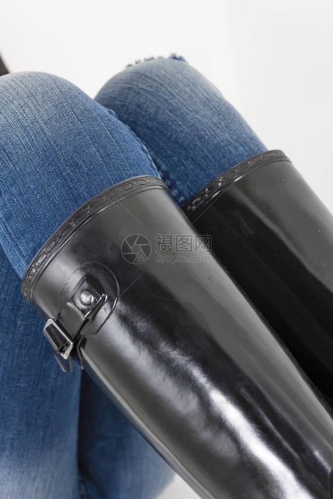 女士黑色橡胶靴搭配蓝色牛仔裤图片