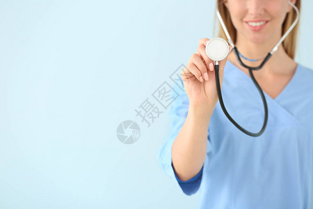 彩色背景上带听诊器的女护士图片