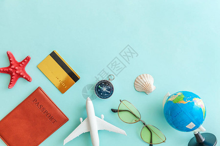 最简单便的平铺有飞机护照太阳墨镜全球金信用卡和蓝糊彩色潮时背景外壳背景图片