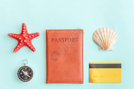 最简单便的公寓内装有护照指南针金信用卡和蓝糊彩色潮流背景的贝壳背景图片