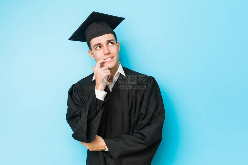年轻的caucasian毕业男子放松想着一些东西看图片