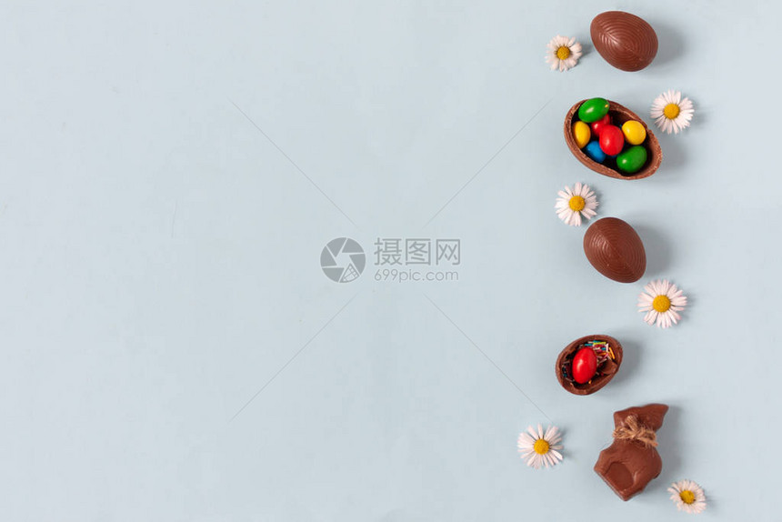 巧克力复活节鸡蛋在面贴蓝色背景的顶部视图上图片