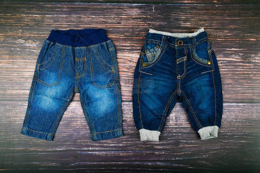 木制背景上的儿童牛仔裤时尚的概念服装的概念深色木质背景男婴和牛仔图片