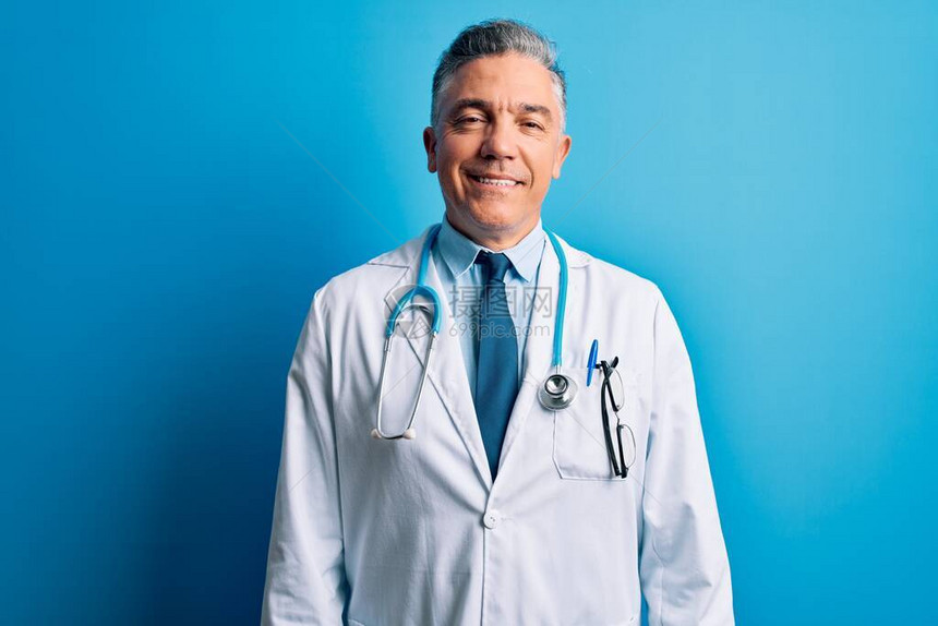 穿着大衣和蓝色听诊器的中年长相英俊的灰发医生图片