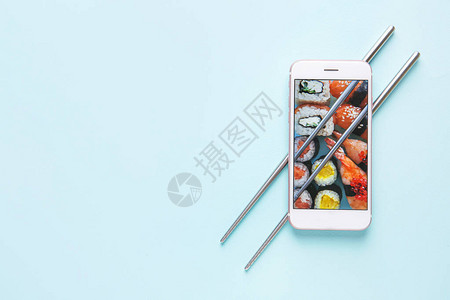 屏幕上带寿司的移动电话和彩色图片