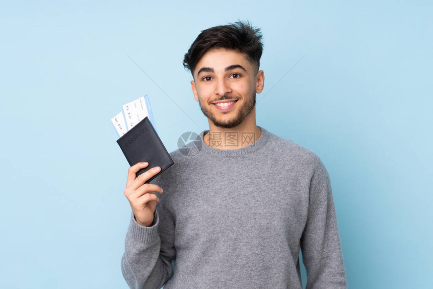 阿拉伯英俊男子在度假时带着护照和飞机票欢乐地享受着蓝图片